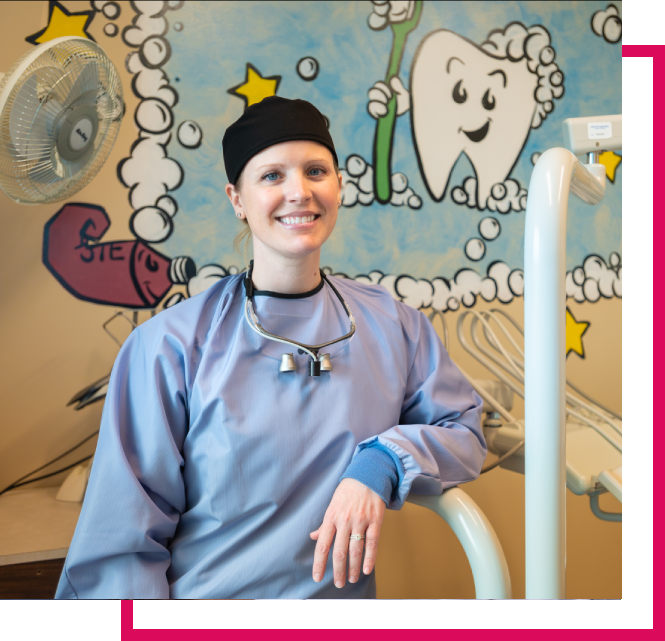 Swope Health dentist smiling in front of mural in exam room