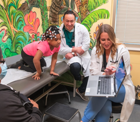 Two pediatricians conducting a checkup on patient